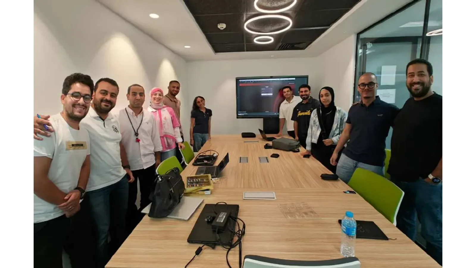 Ali with the e& Egypt DevOps internship cohort in a meeting room at the end of the program